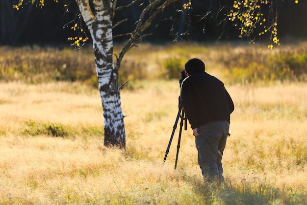 Fotografo naturalista sul campo con la sua fotocamera dslr