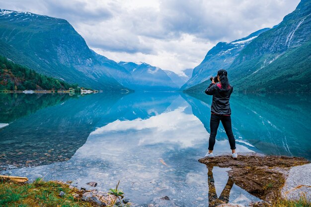 Nature photographer tourist with camera shoots Beautiful Nature Norway natural landscape. lovatnet lake.