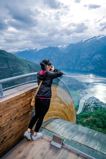 Photo nature photographer tourist with camera shoots. stegastein lookout. beautiful nature norway.