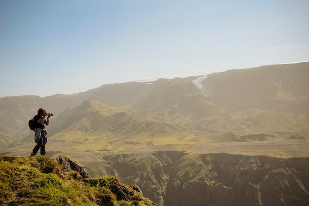 Nature photographer with digital camera on top of the mountain