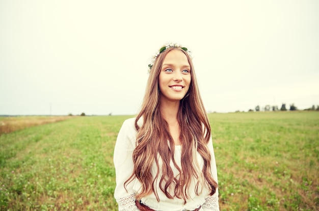 자연, 여름, 청소년 문화, 그리고 사람들의 개념 - 시리얼 밭에 꽃 화환을 쓰고 웃고 있는 젊은 히피 여성