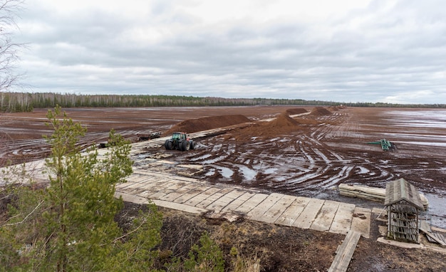 Nature view of a swamp with a peat digging site in a swampy area with a wooden boardwalk and a tract