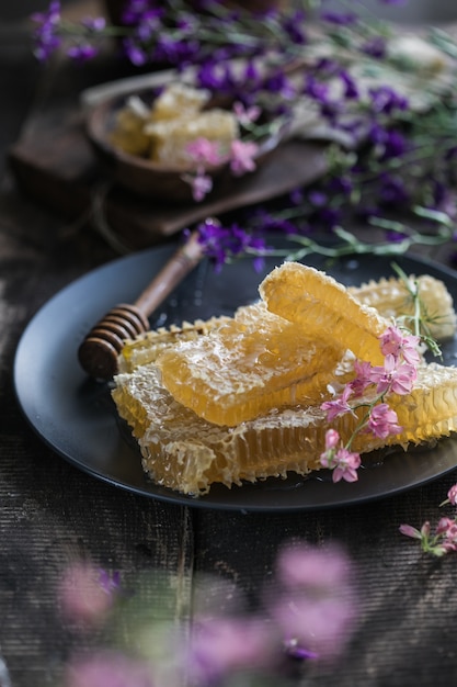 Natura mestolo di miele in legno e favi su sfondo di legno