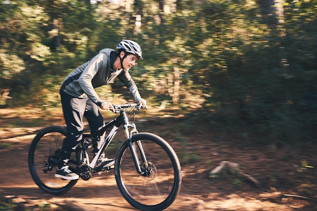 Natuur en gezondheid fietsen met man op de weg voor training, training of cardio-oefening Avontuurlijke extreme sporten en snelheid met mannelijke fietser op de fiets in bospark voor prestatie-uitdaging of pauze