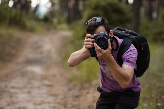 natuur fotograaf. man met camera in het bos. reislust en reislevensstijl