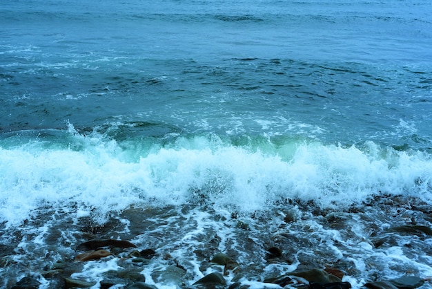 Natuurachtergrond met zeegolven die de kust raken schilderachtig uitzicht op zee tegen bewolkte hemel