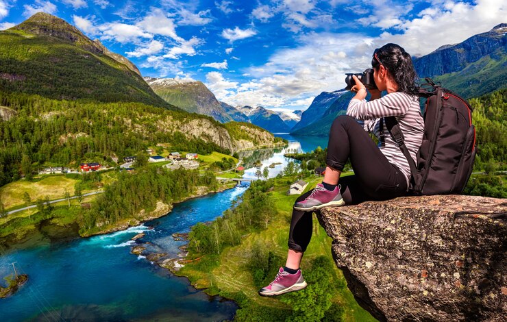 Foto natuurfotograaf toerist met camera schiet terwijl hij op de top van de berg staat. prachtige natuur noorwegen.