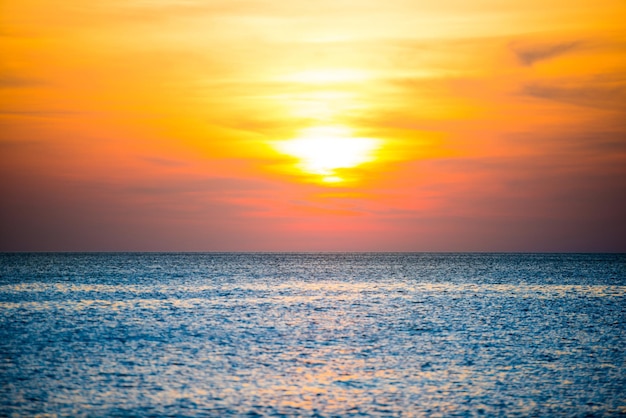 Natuurlandschap met prachtige dramatische oranje zonsondergang over blauwe golfde zee