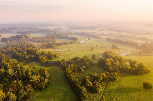 Natuurlandschap met uiterwaarden en oeverbossen verlicht door de ochtendzon