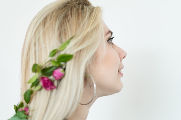 Natuurlijk haardecor. blond meisje dat verse bloem feestelijke toebehoren draagt