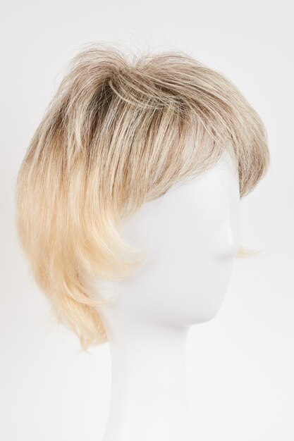 Natuurlijk ogende blonde eerlijke pruik op het hoofd van de witte mannequin Kort haar geknipt op de plastic pruikhouder geïsoleerd op een witte achtergrond