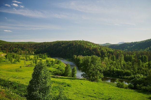 Natuurlijk uitzicht op groene velden op de voorgrond en bergen van kliffen en heuvels.