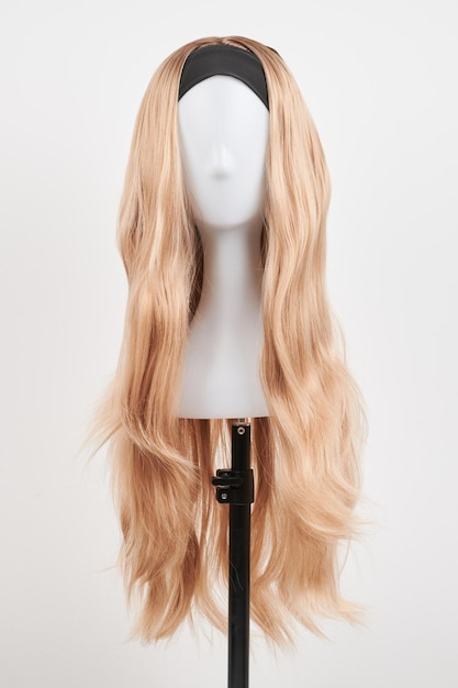 Natuurlijk uitziende blonde pruik op wit mannequin hoofd Lang haar op de plastic pruikhouder geïsoleerd op witte achtergrond voorkant