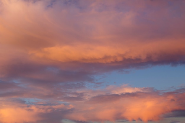 Natuurlijke achtergrond. Blauwe lucht met roze wolken bij zonsondergang. Detailopname.