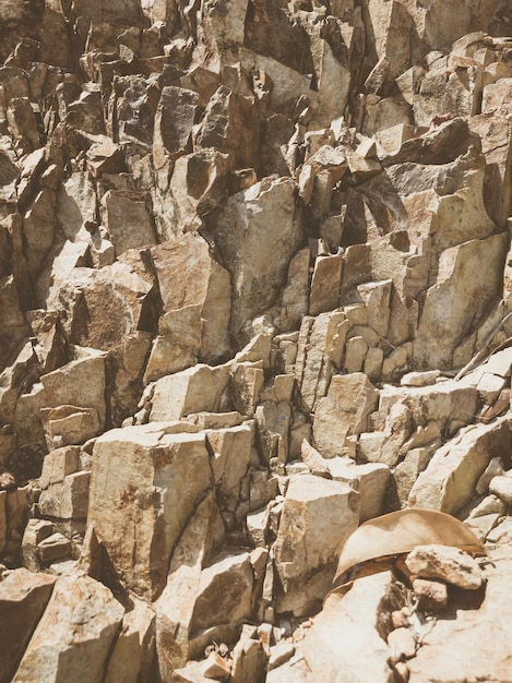 Natuurlijke achtergrond Close-up randen armoedige klif scheuren Grijsbruin steen rots textuur van bergen Vintage en vervaagde matte stijl kleur in getinte foto Concept van geolog bergbeklimmen of hard werken
