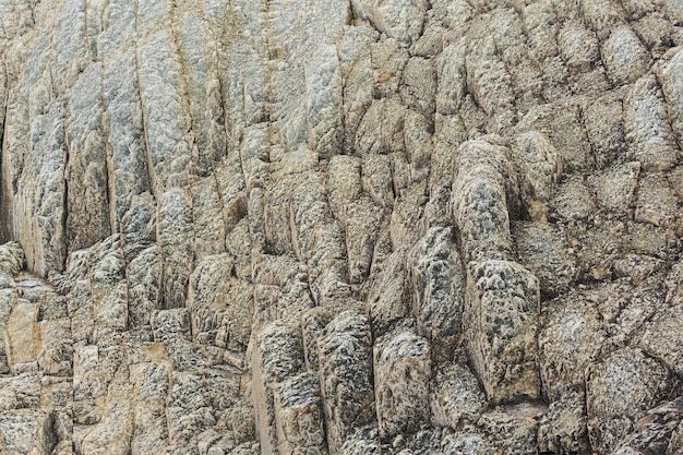 Natuurlijke achtergrondrotstextuur van verweerde zuilvormige basalt gestolde lava