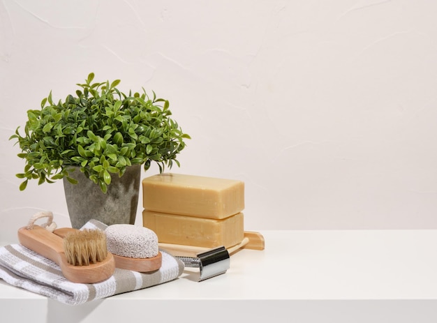 Natuurlijke biologische spa cosmetica Zeep handdoek scheermes borstel Groene plant in een pot Kopieer ruimte voor tekst