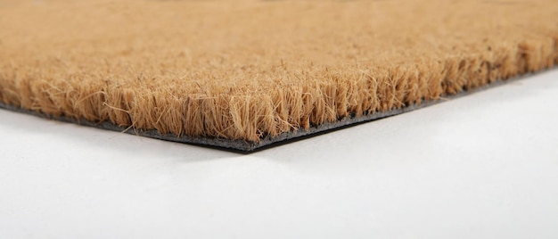Natuurlijke bruine kokosvezel deurmat Eenvoudige natuurlijke droge tapijt en vuil buiten uw ingang Detail close-up van vezel en basis op witte achtergrond