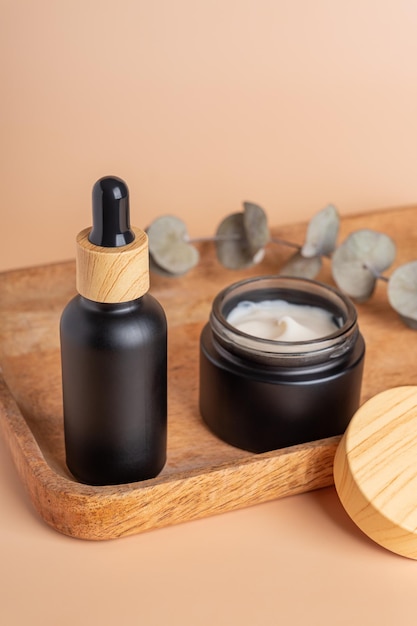 Natuurlijke cosmetica in bamboe en glazen verpakkingen op bruine achtergrond met gedroogde eucalyptusbloemen SPA biologische schoonheidsproducten instellen Huidverzorgingsconcept