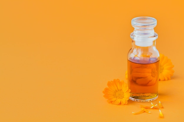 Natuurlijke cosmetische olie, een tinctuur of aftreksel met Calendula-bloemen op sinaasappel