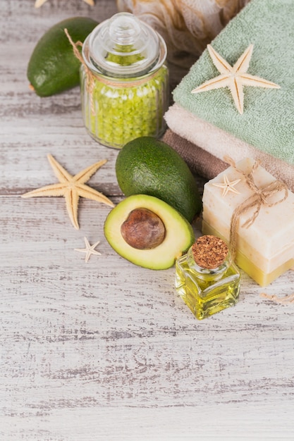 Natuurlijke cosmetische olie en natuurlijke handgemaakte zeep met avocado op witte rustieke houten achtergrond. Gezonde huid-, gezichts- en lichaamsverzorging. SPA en saunaconcept.