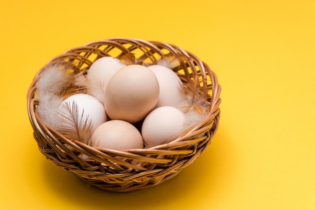 Natuurlijke ecologische eieren en veren in een rieten mand