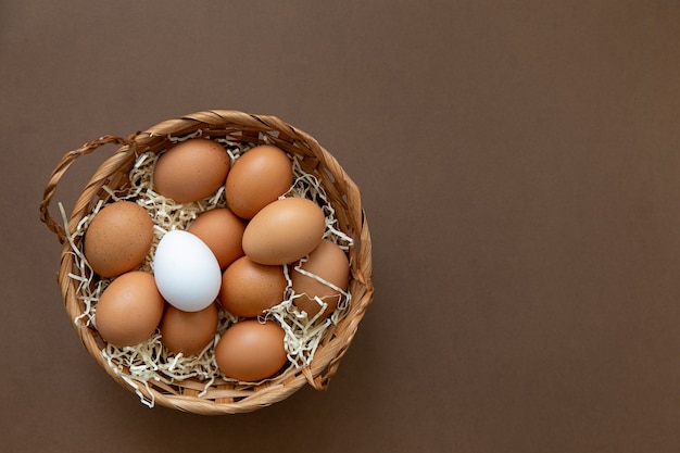 Natuurlijke gezonde voeding en biologisch voedselconcept Ruwe bruine en één witte kippeneieren in een mand