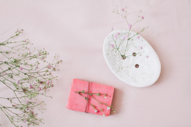 Natuurlijke handgemaakte zeepstaaf met keramische zeepschaal en bloemen spa biologische zeep duurzame levensstijl