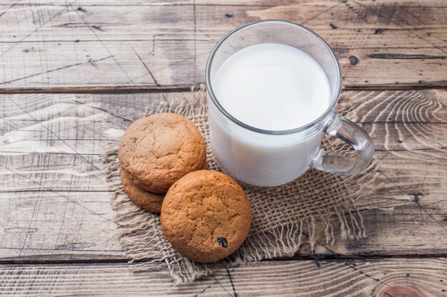 Natuurlijke havermeelkoekjes en een glas melk op een houten achtergrond