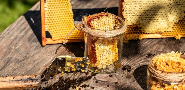 Natuurlijke honingkam en een glazen pot op houten tafel