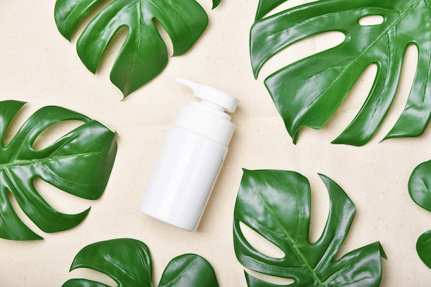 Natuurlijke huidverzorging schoonheidsproduct, cosmetische fles containers verpakking met groene natuur bladeren, blanco label voor biologische spa branding mock-up, kruiden gezonde huidverzorging.