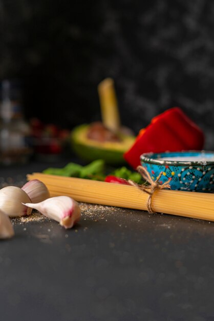 Natuurlijke ingrediënten voor het koken van pasta, rauwe spaghetti vastgebonden met een touw, zout en peper op de tafels