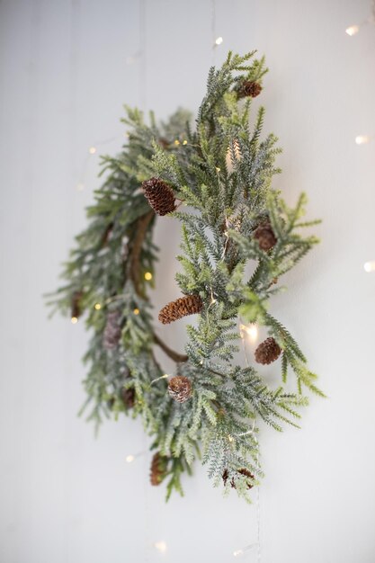 Natuurlijke kerstkrans met lichtjes op een witte muur