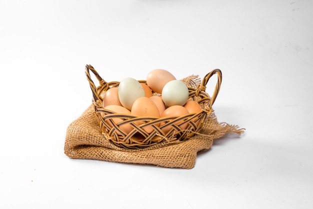 Natuurlijke kleurrijke eieren in de mand op witte achtergrond,