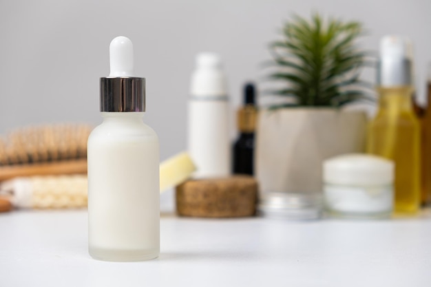 Natuurlijke kruideneco-cosmeticacrème of serum in een glazen pot met pipetdispenser