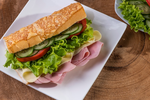 Natuurlijke sandwich op stokbrood met kaas-, ham- en slavulling.