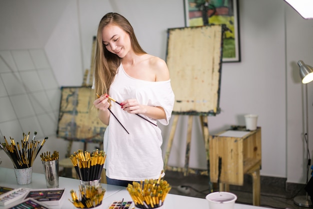 Natuurlijke schoonheid leraar schilder in haar atelier voorbereiden op een kunstles