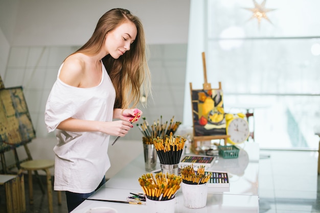 Natuurlijke schoonheid leraar schilder in haar atelier voorbereiden op een kunstles