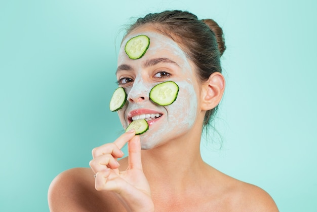 Natuurlijke schoonheid. Meisje koelen klei gezichtsmasker met komkommer maken.