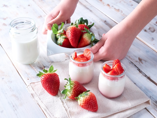 Natuurlijke yoghurt en verse aardbeien, glas melk, allemaal op een houten tafel