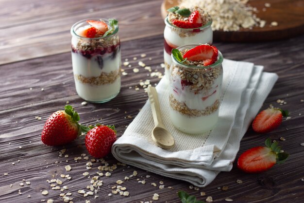 Natuurlijke yoghurt in potje met jam, muesli en verse aardbei