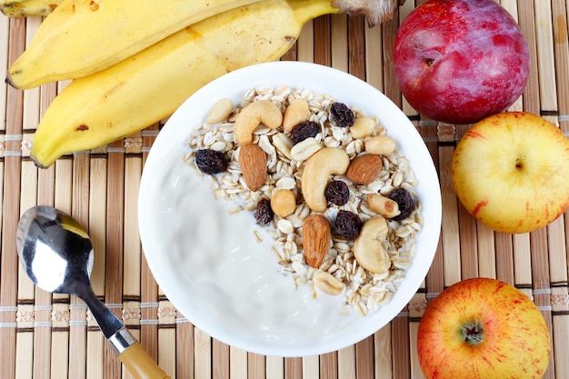 Natuurlijke yoghurt met zelfgemaakte granola en noten in een keramische kom op een tafeltop