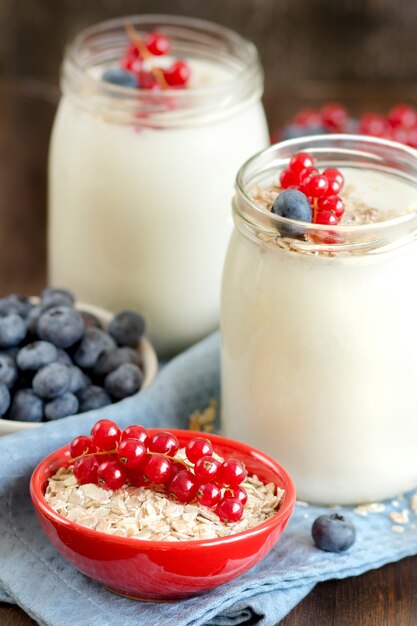 Natuurlijke yoghurt, verse bessen en granen op een donkere houten tafel. Gezond ontbijt concept