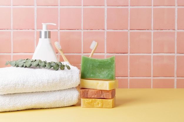 Natuurlijke zeep en cosmetica flessen katoenen handdoeken milieuvriendelijke lichaamsverzorging op tafel in een badkamer wandtegels keramische achtergrond