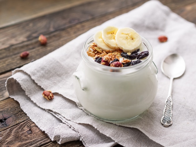 Natuurlijke zelfgemaakte yoghurt in een glazen pot met muesli