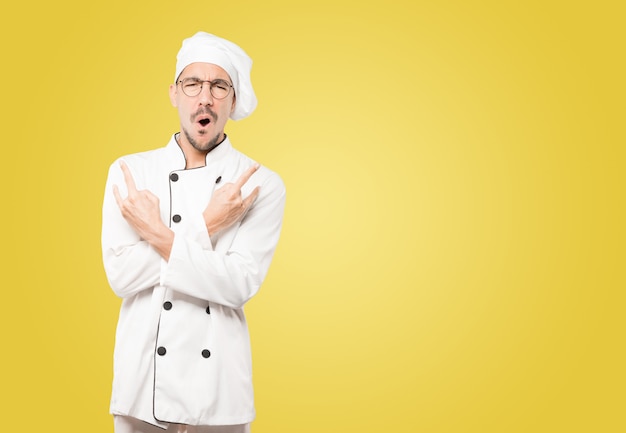 Naughty young chef making a rock gesture