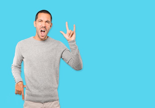 Naughty young man making a rock gesture