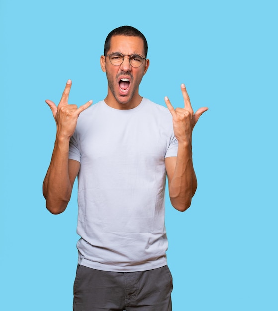 Naughty young man making a rock gesture