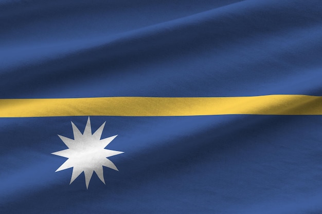 Photo nauru flag with big folds waving close up under the studio light indoors the official symbols and colors in banner