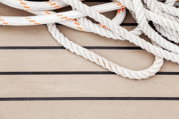 Photo nautical rope lies on the teak deck of a yacht